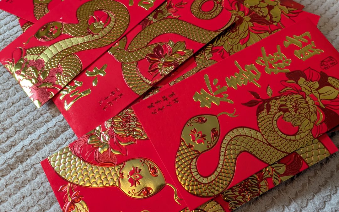 Children and families taking part in a Lunar New Year envelope exchange during our Breaking and cultural learning session at KL Dance in Moss Bank, St Helens.